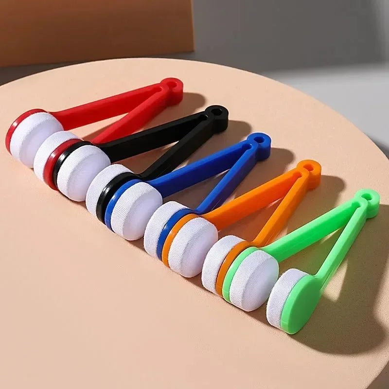 A collection of colorful portable double-sided glasses cleaning brushes with microfiber pads arranged on a light background.