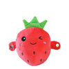 A bright red strawberry shaped plush metronome toy with green leaves and small eyes.