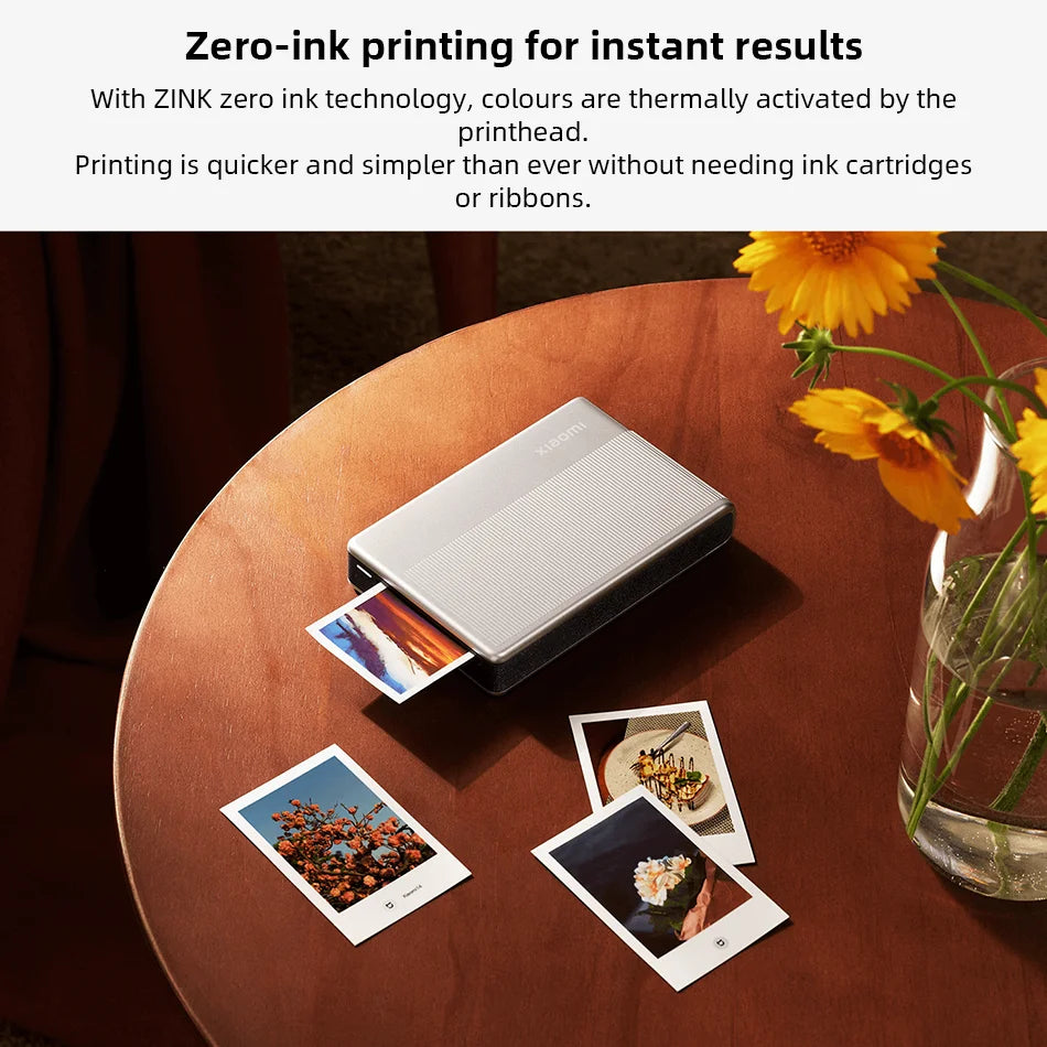 A portable photo printer is shown on a wooden table with several printed photos.