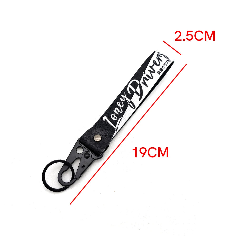 A black leather strap keychain with the text Lonely Driven engraved on it, measuring 19cm long.