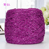 A ball of metallic purple silk crochet yarn with a shimmering texture for knitting and macrame.