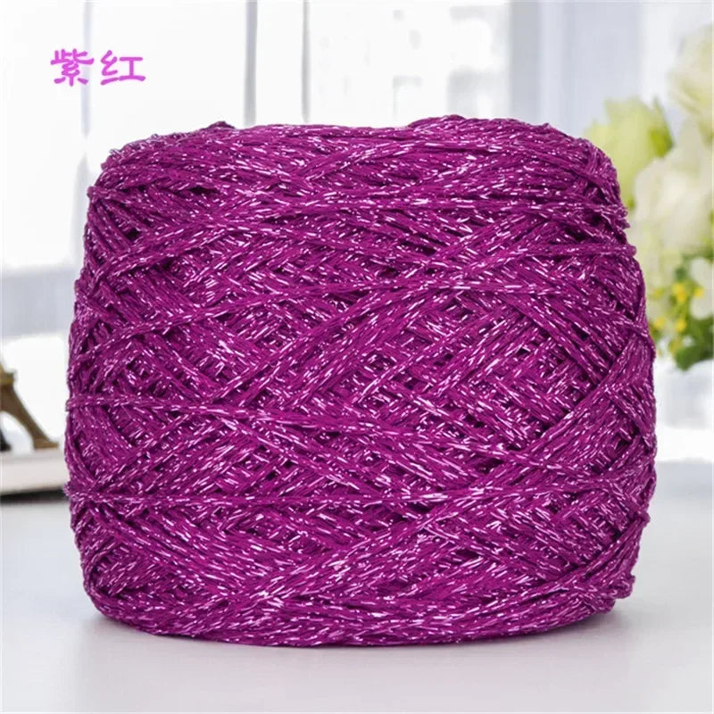 A ball of metallic purple silk crochet yarn with a shimmering texture for knitting and macrame.