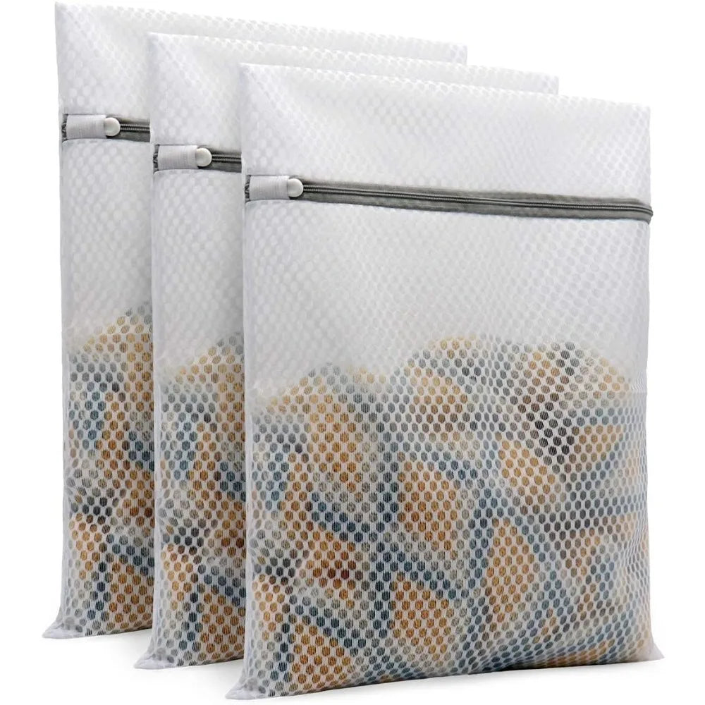 A set of three clear mesh laundry bags filled with delicates and stored in a gray fabric pouch.