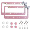 Pink rhinestone license plate frame with a bow accent and mounting hardware.