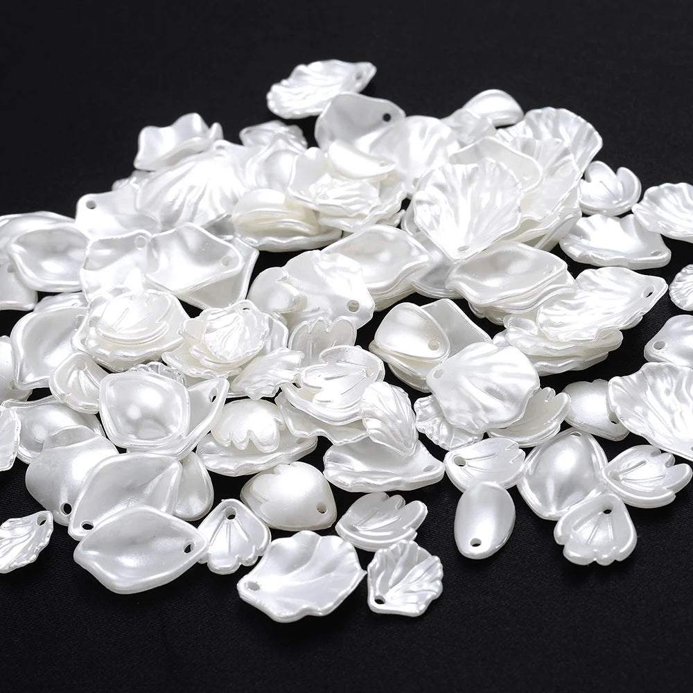 A pile of 100 clear and white acrylic pearl spacer beads for jewelry making.