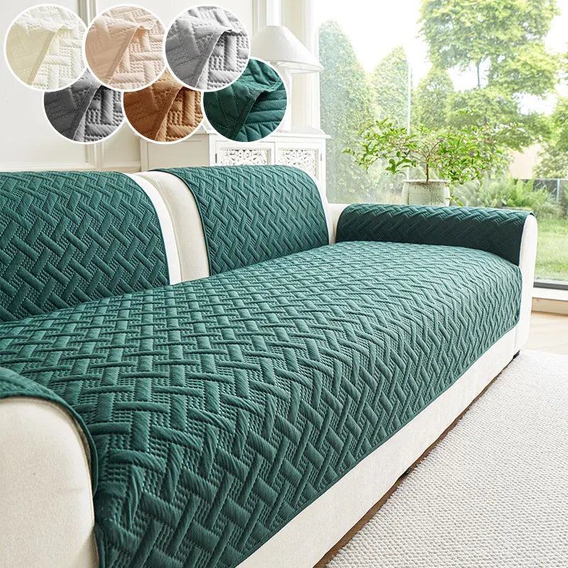 A dark green quilted anti-slip sofa cushion is displayed on a white sofa with light beige fabric.