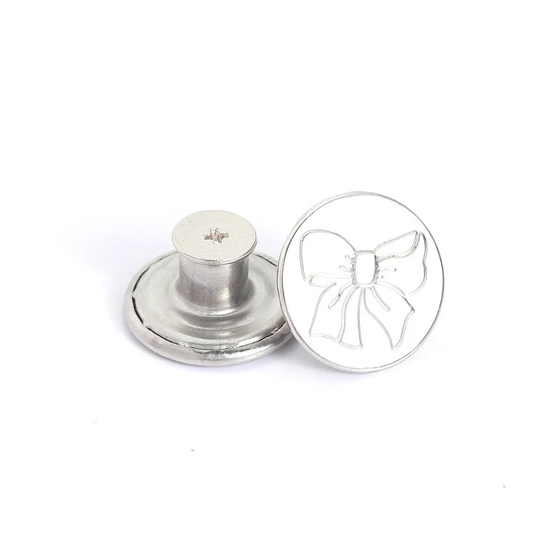 Silver replacement buttons for jeans, featuring a decorative bow design.