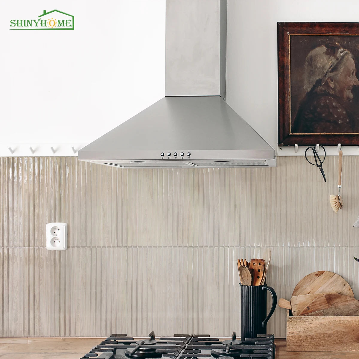 Campana extractora de acero inoxidable instalada sobre una encimera con azulejos de salpicadero de veta de madera clara.