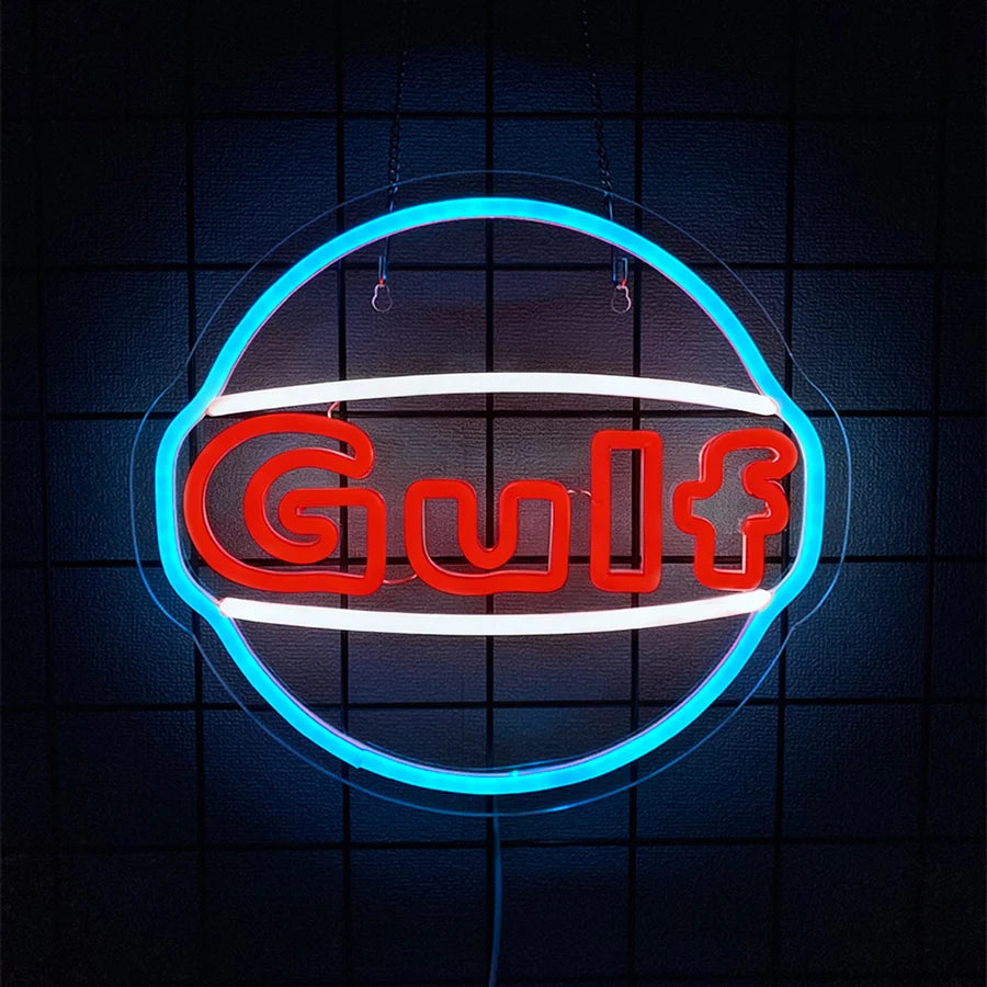 A glowing neon sign shaped like a truck emblem with the word Gulf in red and white on a dark background.
