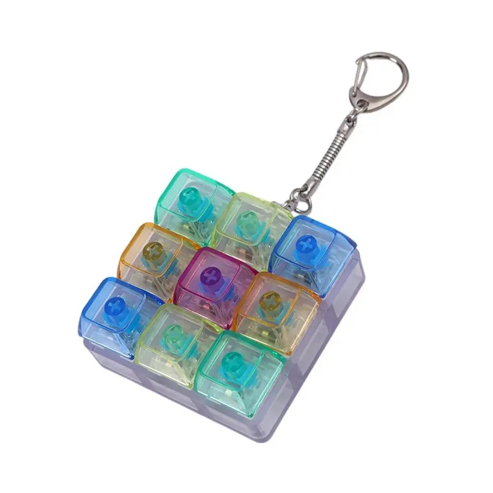 Una carcasa de plástico transparente que contiene múltiples teclados mecánicos mini con luces LED, sujetos a un anillo de lla