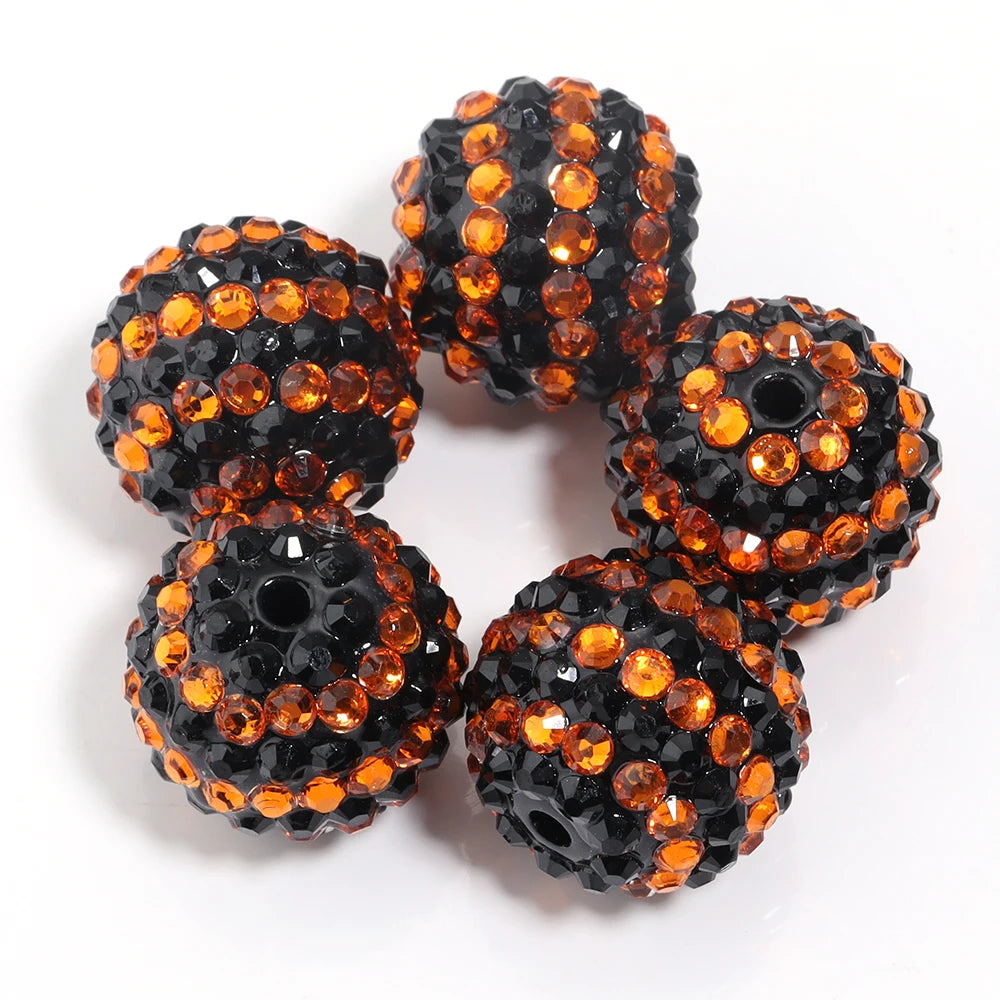 A set of five resin rhinestone beads with a two-tone orange and black striped design.
