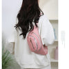 Sac banane en nylon à motif matelassé rose porté par une femme avec un sweat blanc.
