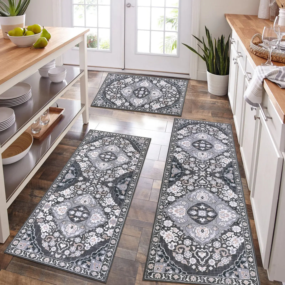 A long rectangular gray and white patterned kitchen rug placed on a wooden floor.