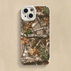 A silicone phone case featuring a forest camouflage pattern of tree branches and autumn leaves.