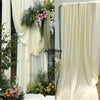 Elegant cream fabric draped as a backdrop with greenery and flowers for decor