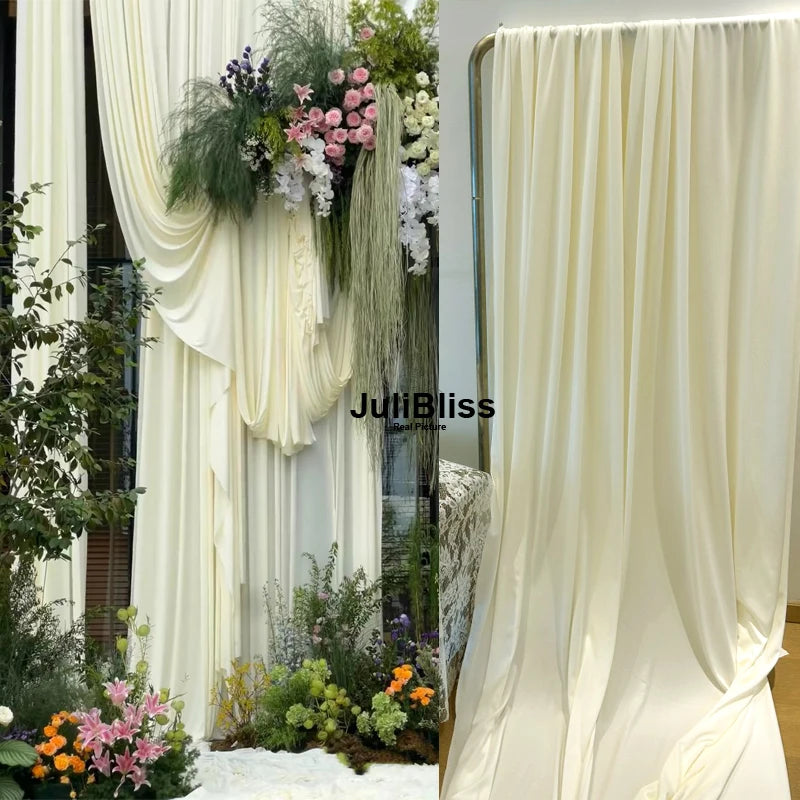 Elegant cream fabric draped as a backdrop with greenery and flowers for decor