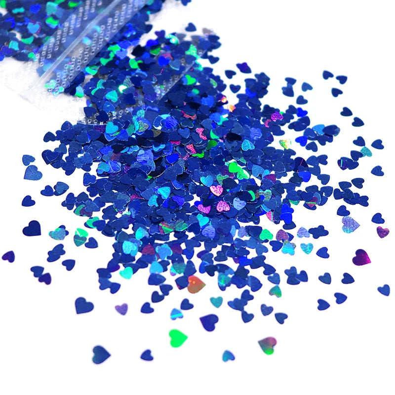 A pile of shiny holographic star sequins in various shades of blue and green.
