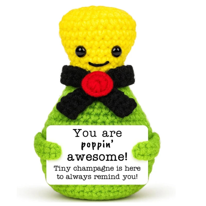 Handmade crochet yellow animal doll with a black bow and a green body, featuring a positive message card.