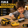 A boy is playing with a yellow remote control construction vehicle toy on a wooden table.