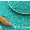 A small, light brown seashell is placed on a turquoise surface next to a measuring tool.