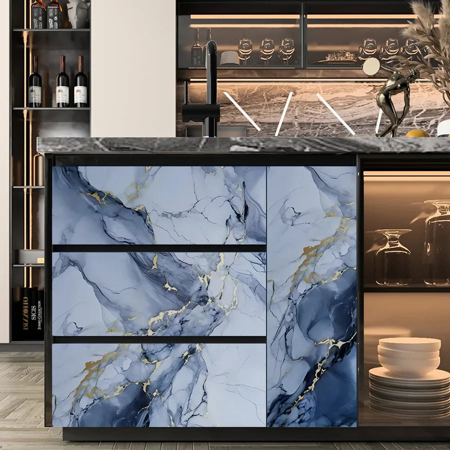 A kitchen backsplash featuring blue marble with gold veining, installed on a dark countertop.