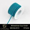 A spool of turquoise glass rhinestones used to create a cup chain for DIY clothing decoration.