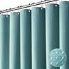 A set of vertical, waffle-textured, teal shower curtains hanging from a metal rod.