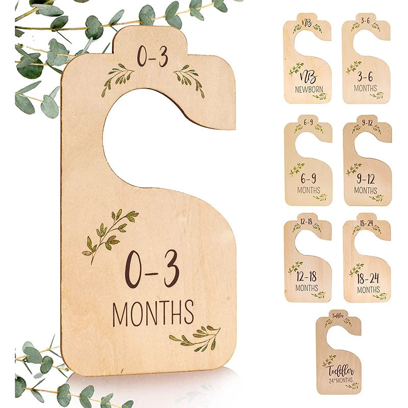 A set of eight wooden baby closet dividers for organizing clothes, ranging in size from newborn to 24 months.