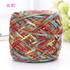 A ball of multi-colored metallic silk crochet yarn with shades of red, blue, yellow, and gray.