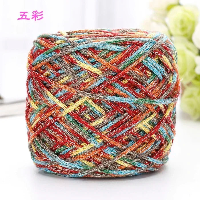 A ball of multi-colored metallic silk crochet yarn with shades of red, blue, yellow, and gray.