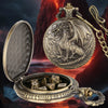 A silver dragon-themed pocket watch case is open, revealing a set of seven metal polyhedral dice.