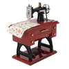 A vintage clockwork sewing machine music box with a dark wooden body and brass accents.