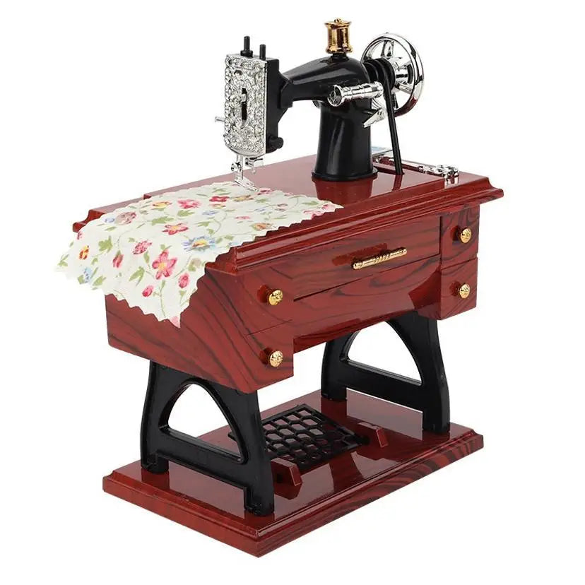 A vintage clockwork sewing machine music box with a dark wooden body and brass accents.