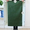 A person holds up a dark green heavy-duty canvas laundry bag with a drawstring closure, showing its dimensions.