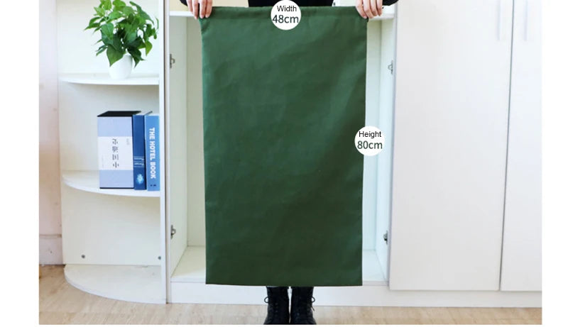 A person holds up a dark green heavy-duty canvas laundry bag with a drawstring closure, showing its dimensions.