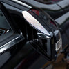 Close-up of a black car rearview mirror with rhinestone rain guards installed.
