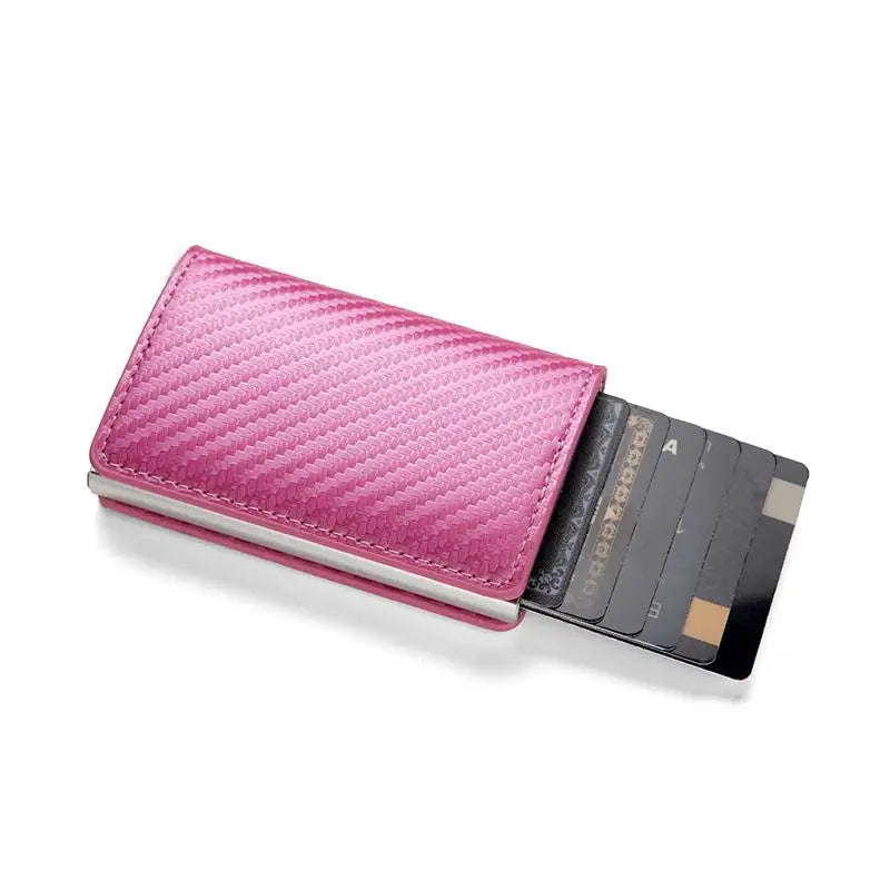 A pink quilted slim leather card holder with a black sleeve and multiple cards.