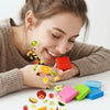 A woman is applying silicone diamond painting clay to a surface, with various colored pieces scattered around.