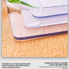 A clear PVC waterproof table protector shows a rounded corner design on a wooden surface.