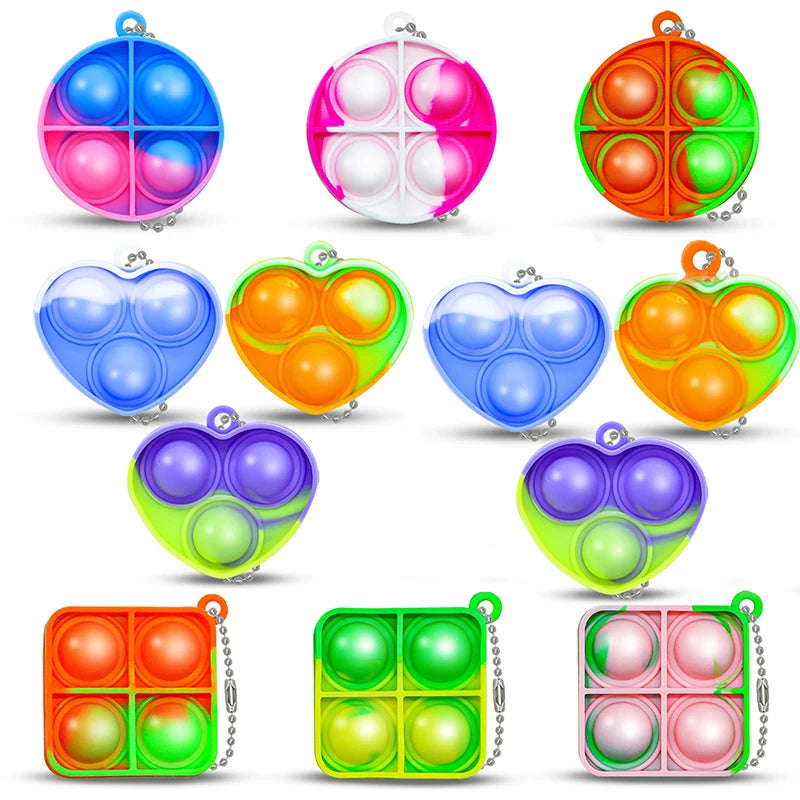 A collection of colorful mini pop keychain fidget toys in various shapes and colors.