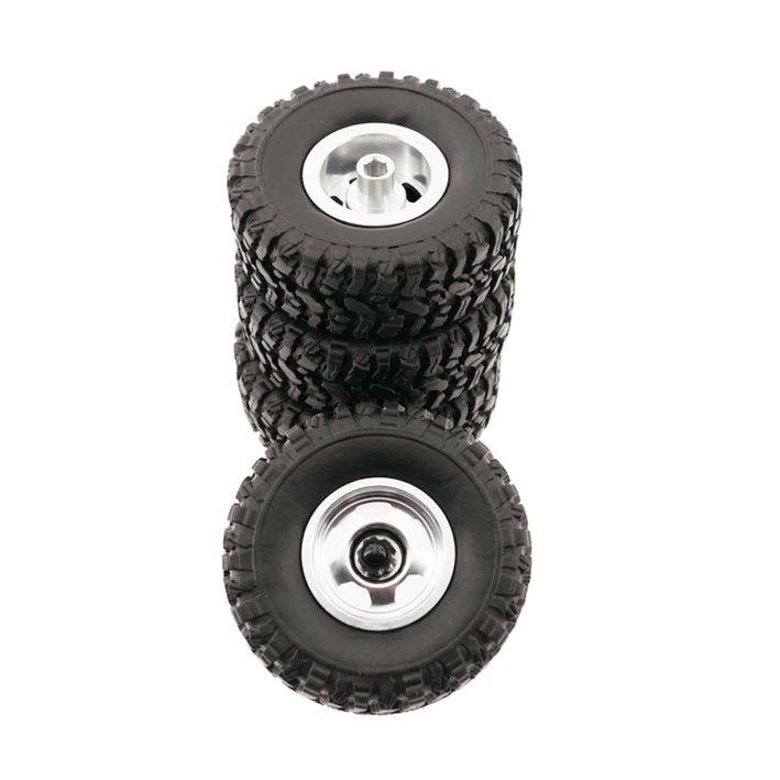 A stack of four black off-road RC car upgrade wheels with metal rims and soft tires