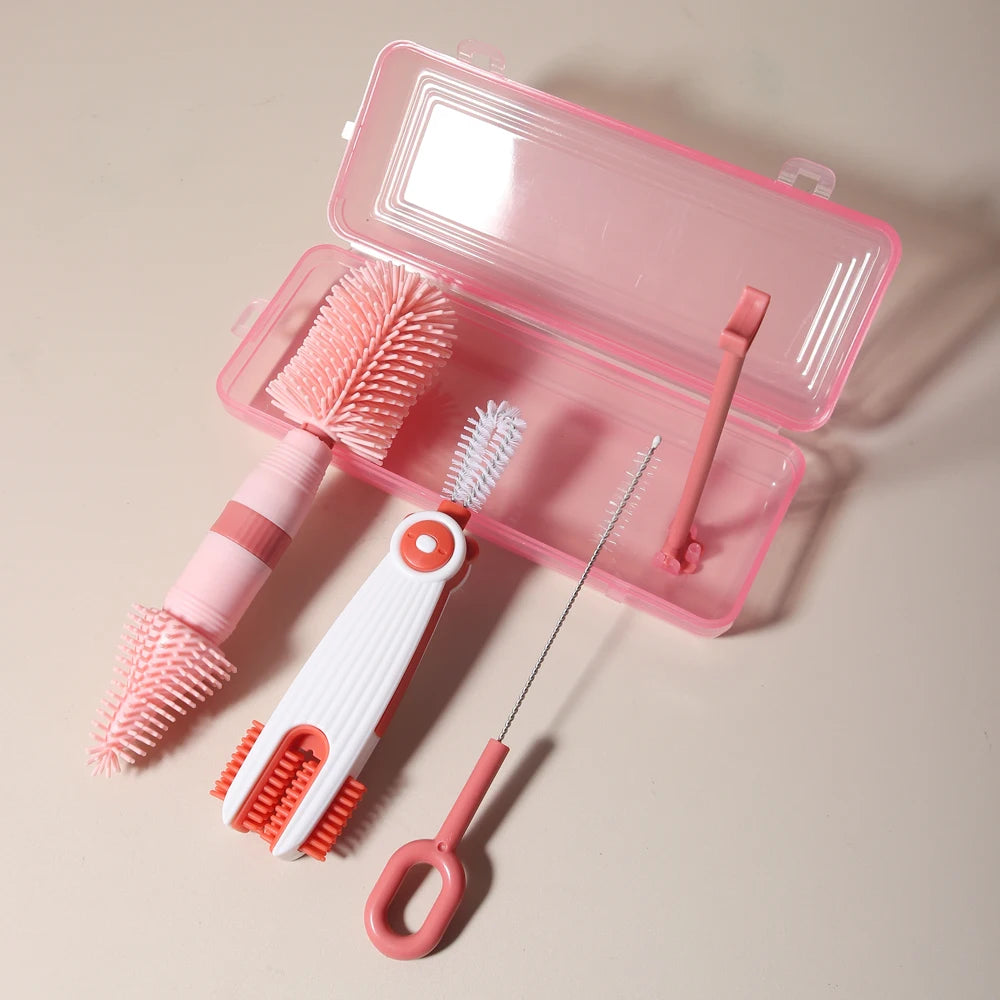 A pink silicone baby bottle cleaning set with a brush and a cleaning tool displayed in an open pink case.