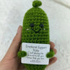 Handcrafted pickle plush toy with a green fuzzy body and a black muppet face