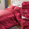 A set of deep red silky duvet covers featuring corner ties and a zipper, shown in various folds.