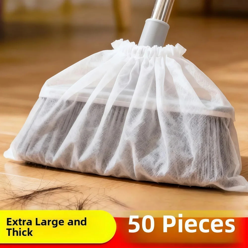 A white disposable broom cover made of sheer fabric with a thick, ruffled edge is shown on a wooden floor.