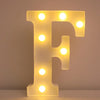 A glowing yellow LED letter F night light mounted on a white surface.