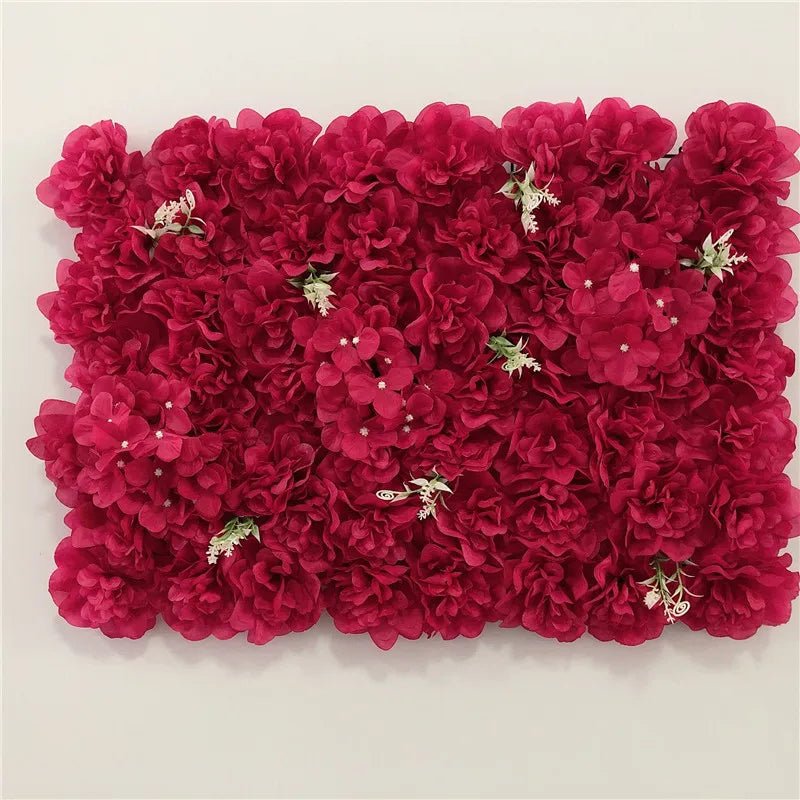 A dense wall panel of deep magenta silk rose flowers used for weddings and events.