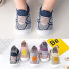 A pair of knitted baby shoes in gray and white with blue accents shown from the top view.