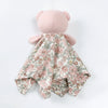 A pink stuffed animal with a floral patterned fabric covering its body.