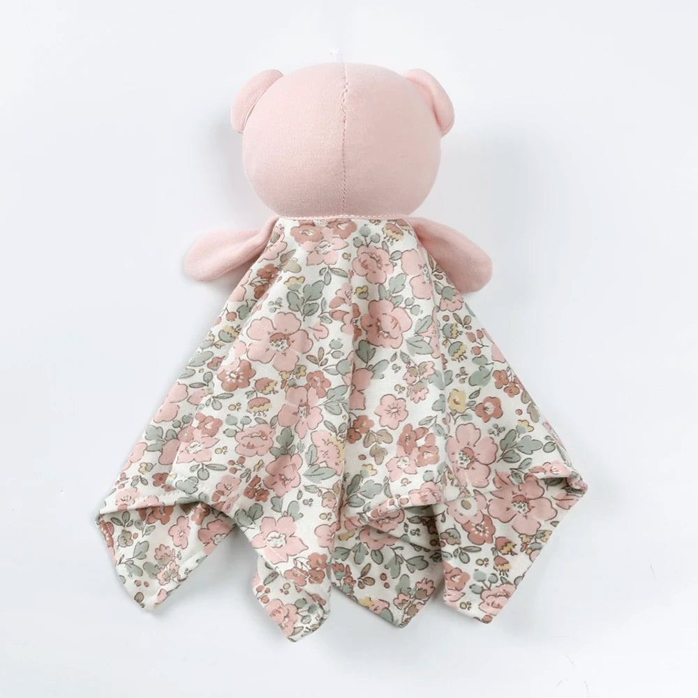 A pink stuffed animal with a floral patterned fabric covering its body.